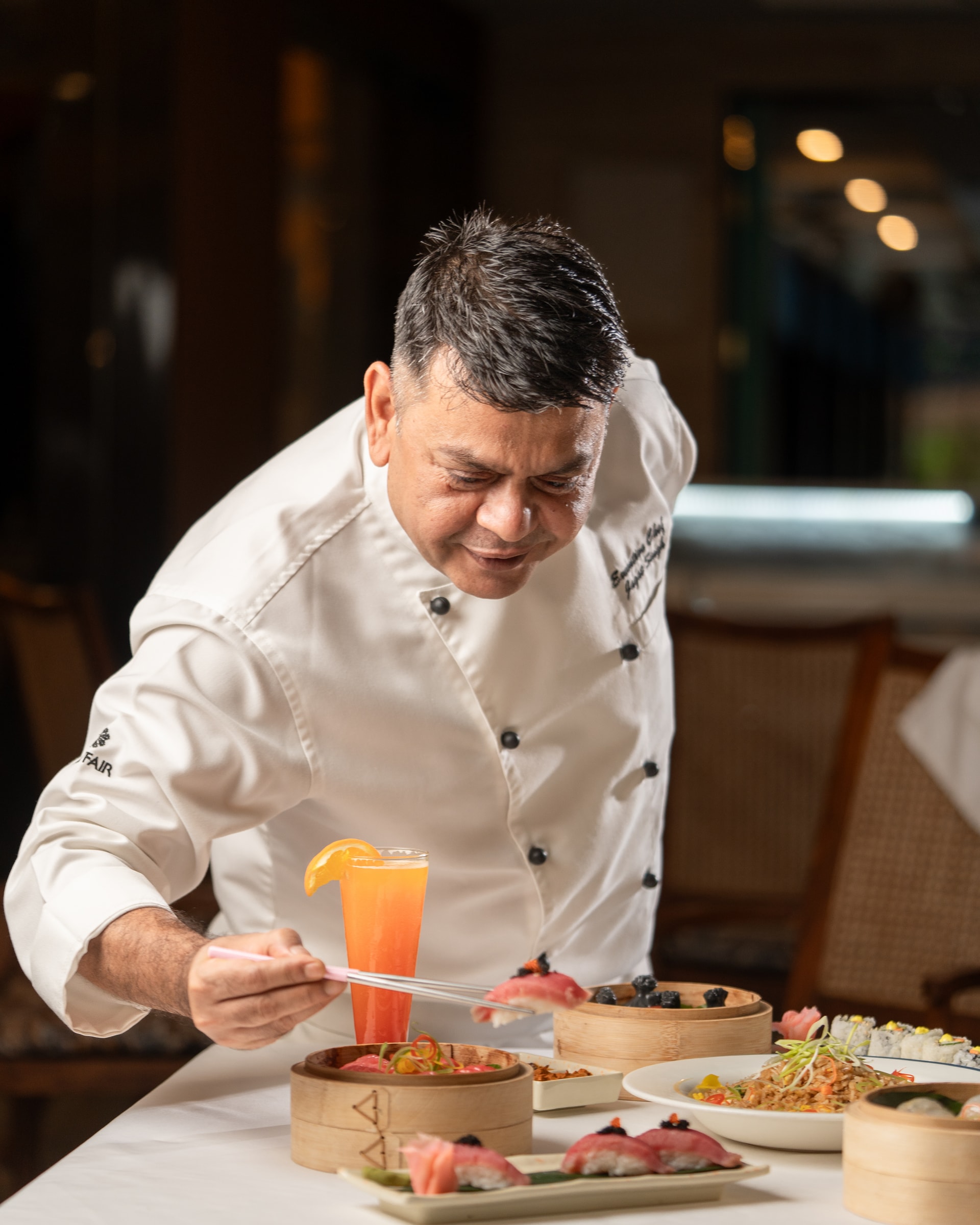 A MAYFAIR chef plating sushi with chopsticks