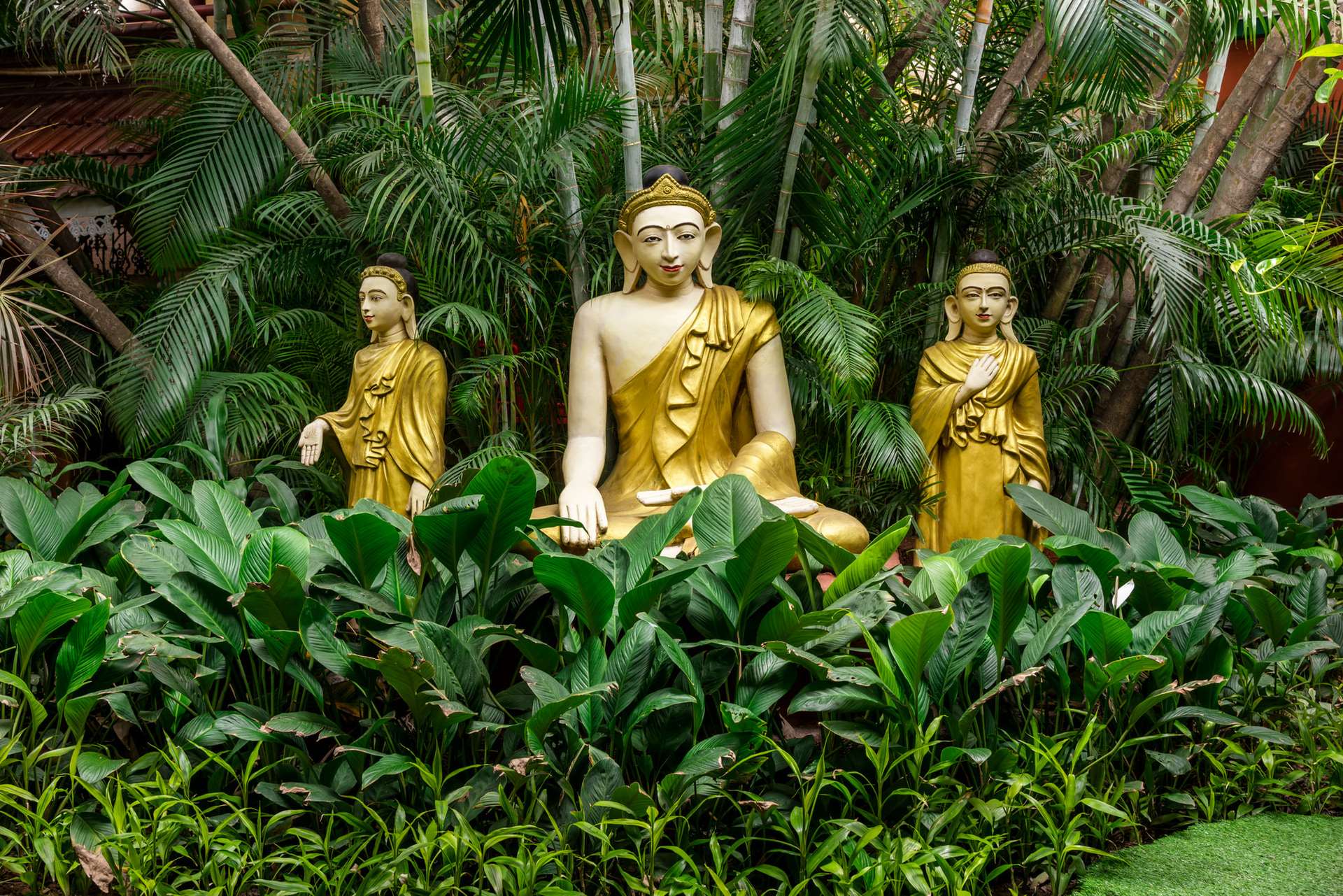 Golden Buddha statues surrounded by lush tropical garden at Mayfair Lagoon Bhubaneswar