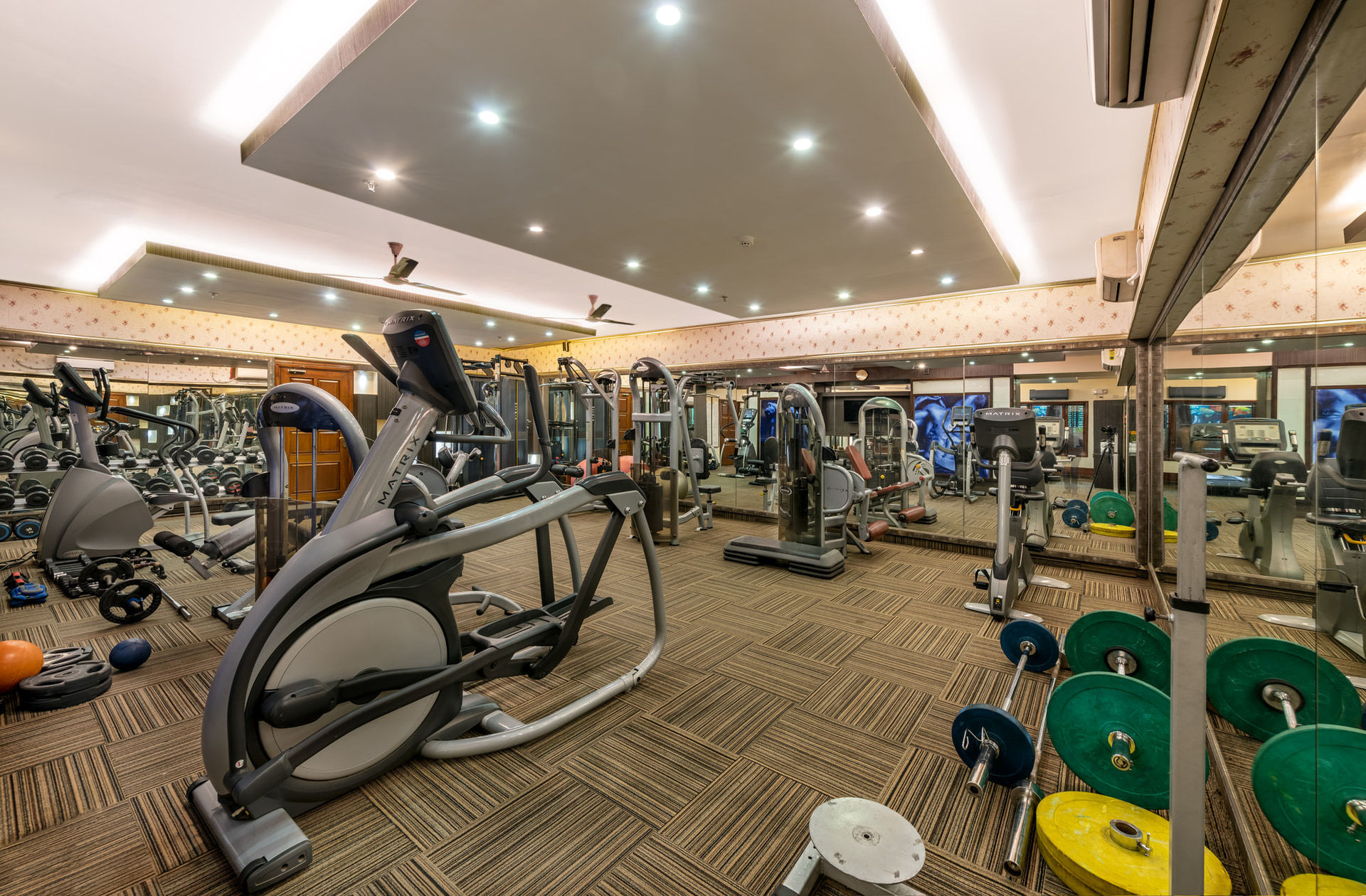 Well equipped gymnasium at Mayfair Lagoon, Bhubaneswar, featuring modern cardio and fitness machines with spacious interiors and bright lighting