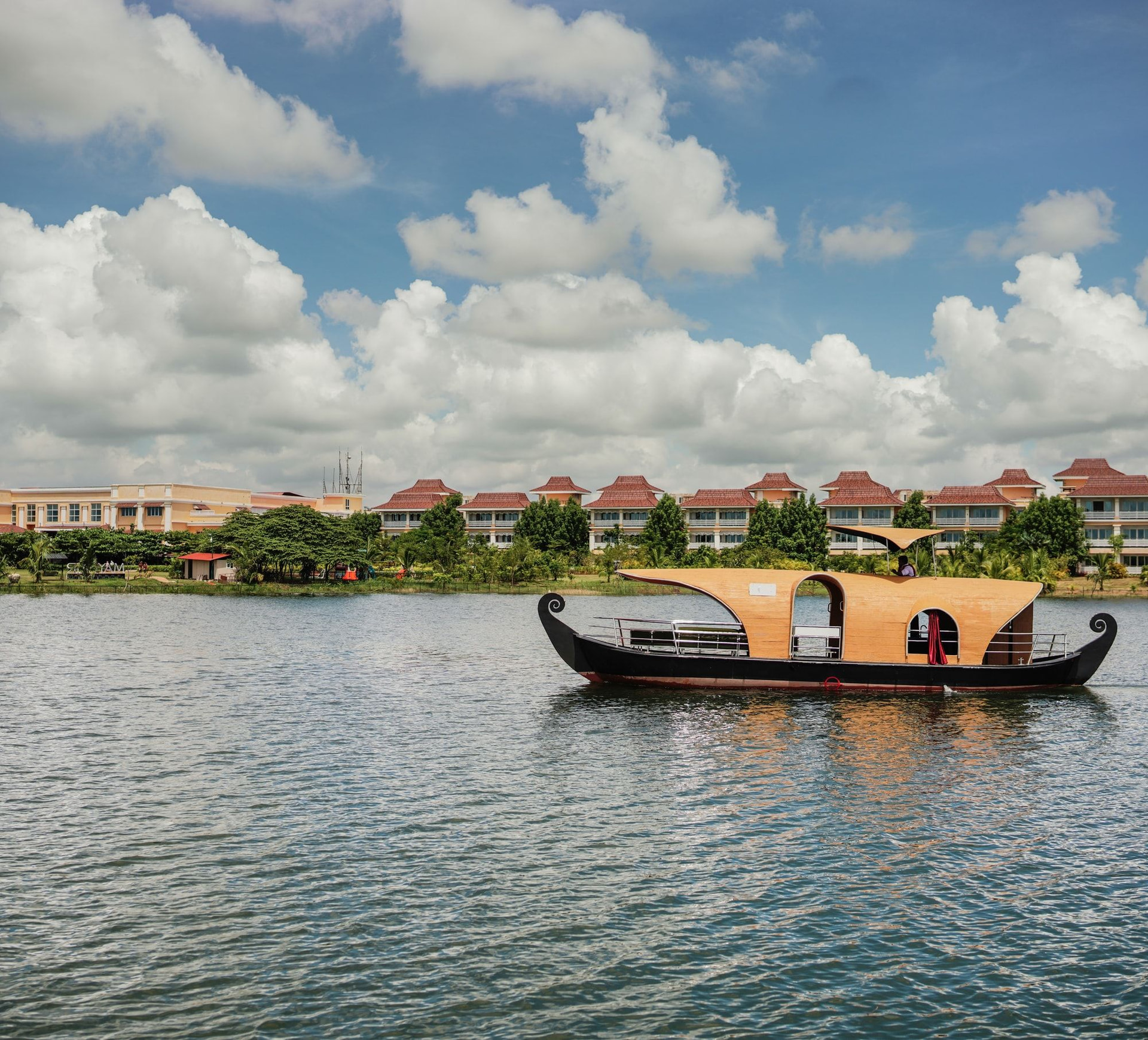 A boat on the lake at MAYFAIR Lake Resort, the resort's tiled roofs across the water