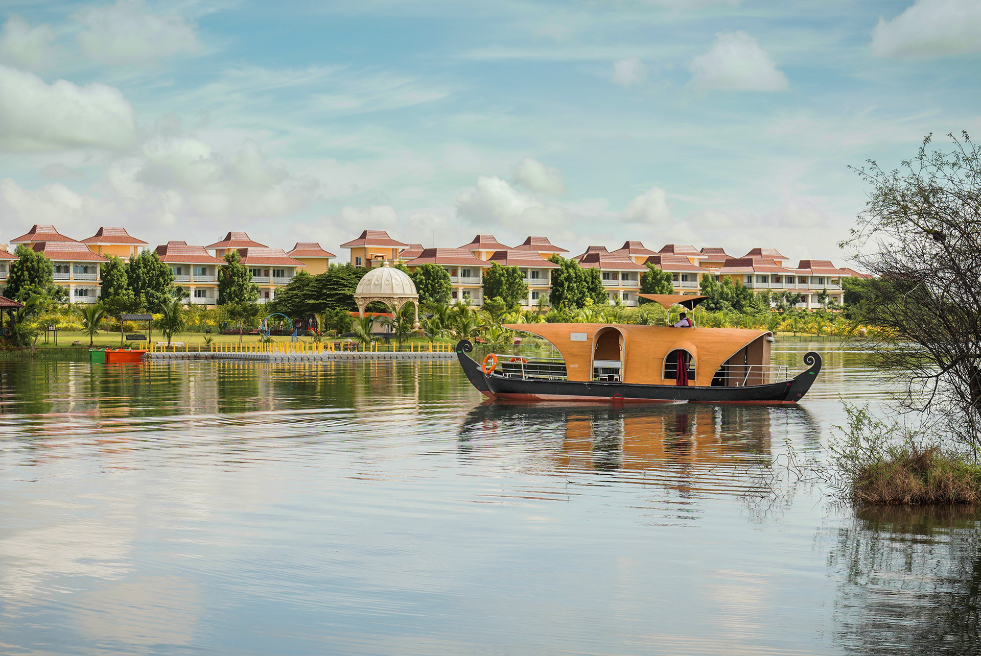 MAYFAIR Lake Resort, Raipur, across its lake with a houseboat crossing