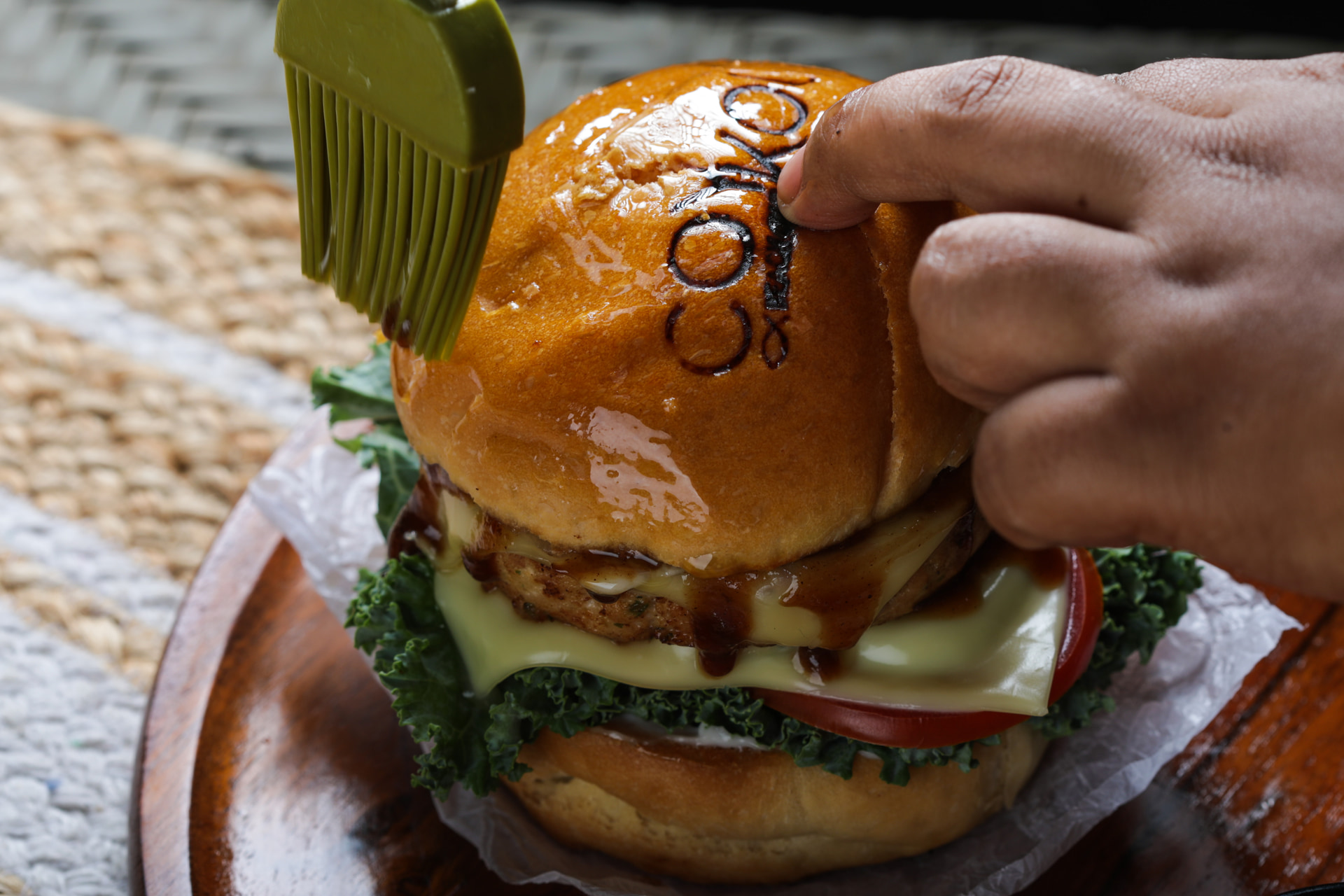 A burger lifted from the board by hand